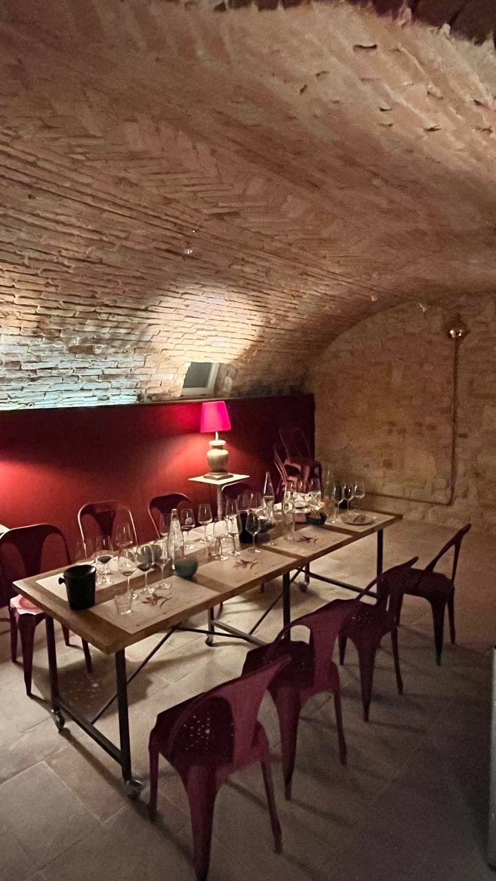Tavolo apparecchiato per una degustazione in una cantina con volta in mattoni