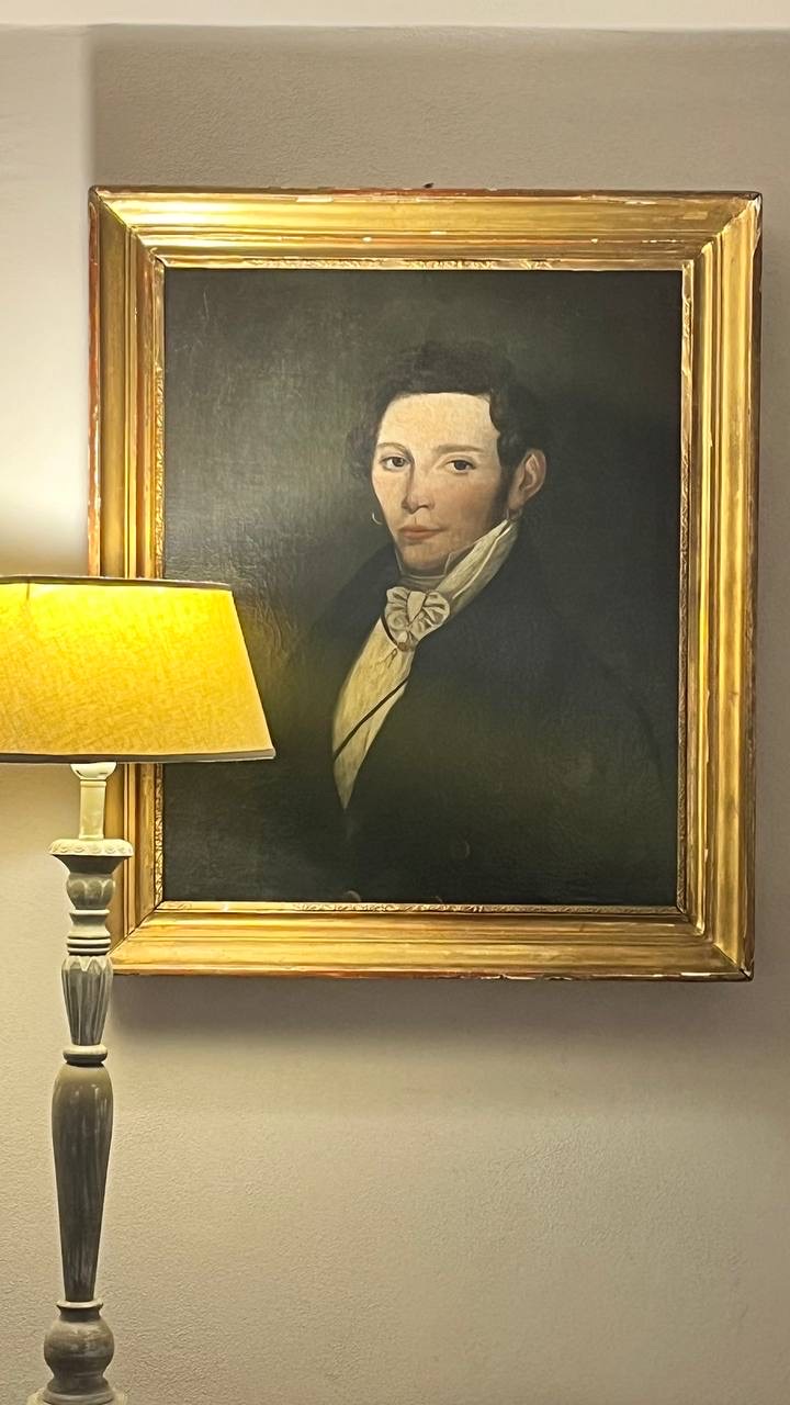 Ritratto ottocentesco con cornice dorata accanto a una lampada
