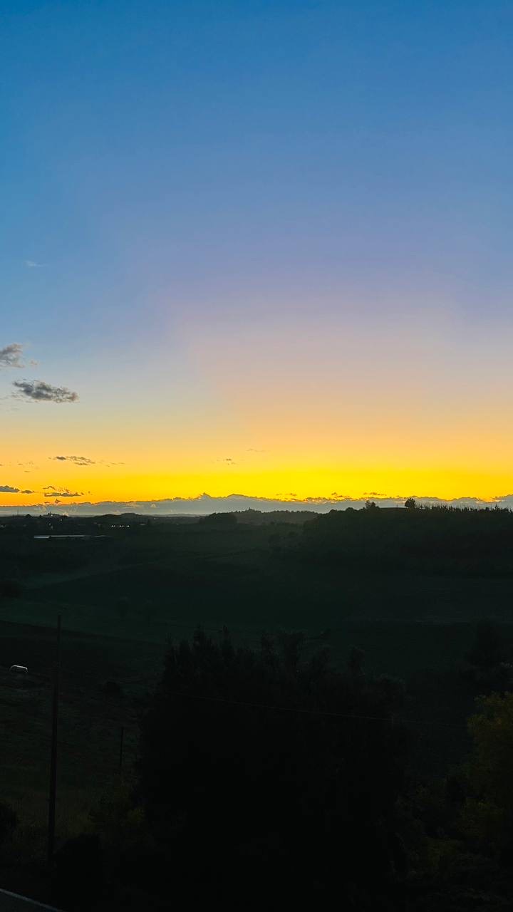 Tramonto giallo all'orizzonte sulle colline